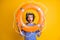 Photo of amazed guy in scuba goggles gear hold life buoy near face wear frock isolated over yellow color background