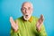 Photo of amazed senior grandpa surprised face hands wear eyeglasses green pullover isolated blue color background