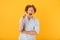 Photo of amazed young man 20s screaming and pointing finger upward at copyspace, isolated over yellow background