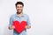 Photo of amazing indian guy holding large red paper heart inviting girlfriend to romantic date wear specs casual denim