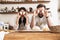 Photo of amusing couple having fun while cooking together in kitchen at home