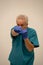 Photo of an angry doctor punching fist with blue gloves