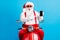 Photo of astonished grey white hair bearded santa claus x-mas christmas scooter driver rider point finger smartphone
