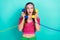 Photo of astonished impressed girl straight hairdo pink top headband talking on landline phones  on turquoise