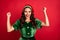 Photo of astonished lady raise fists celebrate victory wear elf costume hat isolated red color background