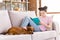 Photo of attentive cute schoolgirl dressed pink t-shirt sitting couch reading book dachshund puppy indoors room home