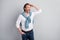 Photo of attentive funny mature guy dressed white shirt pullover shoulders looking far away arm hand head isolated grey