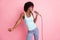 Photo of attractive dark skin girl singer microphone stage wear summer outfit isolated on pastel pink color background