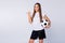Photo of attractive lady direct thumb finger side empty space advising watch soccer match banner hold leather ball wear