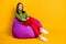 Photo of attractive lady sit comfortable violet bean bag wear green sweater red pants white sneakers  yellow