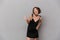 Photo of attractive woman 20s wearing black dress smiling at cam