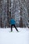 Photo from back of athlete skier in forest at winter