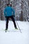 Photo from back of athlete skier in forest at winter