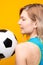 Photo from back of blonde with soccer ball on yellow background