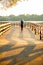 Photo from back of sports woman running on wooden bridge on summer.