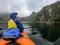 Photo from back of woman tourist with paddle canoe floating along river