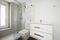 Photo of a bathroom with a bench sink cabinet, a white towel warmer wall radiator