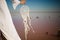 Photo of beautiful boho styled model wearing white on the beach in sunset. Dream catchers blown around by a light sea breeze