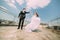 Photo of beautiful bride and groom dancing on roof top at sunny day