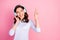 Photo of beautiful cheerful lady use cool modern technology headphones enjoy youth music song good mood direct finger up