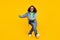 Photo of beautiful funky african lady dressed jeans green hoodie dark eyewear dancing smiling isolated yellow color