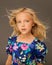 Photo of a beautiful Girl 7-8 years old in bright summer clothes with long blonde hair flying in wind. Concept of baby hair care,