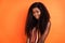 Photo of beautiful lovely charming stunning african woman with long curly brunette hair isolated on orange color