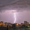 Photo of beautiful powerful lightning over big city, zipper and thunderstorm, abstract background, dark blue sky with bright
