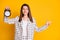 Photo of beautiful smiling brown hair woman checkered jacket hold alarm pointing looking empty space isolated yellow