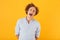 Photo of beautiful young guy 20s with curly hair laughing or screaming at camera with open mouth, isolated over yellow background
