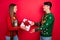 Photo of best friends exchange gifts celebrate x-mas party wear ugly pullover isolated red color background