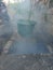 Photo Big and Contrentated Smoke fogging by to kill dengue / aedes aegypti mosquito using blowing machine with sun flare