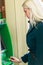 Photo of blonde in coat at green cash machine