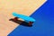 Photo of a blue skateboard against a two-color artificial surface background.Sports and recreation.