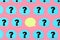Photo, blue stickers with question marks on a pink background. In the center is an empty yellow sticker. A bright