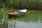 A photo of a boat on a lake near a path full of grass.