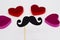 Photo booth props Black Mustache against blurred hearts on white background