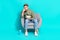 Photo of bored man hold popcorn soda sit armchair watch movie wear pullover isolated blue color background