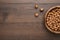 Photo of a bowl full of hazelnuts on brown wooden table