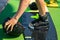 Photo of a boy standing on a wakeboard on land and preparing for sports. He reached for his helmet. Safety precautions for extreme