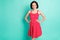 Photo of brightly smiling cute nice fascinating girlfriend wearing vivid red dress while isolated with teal background