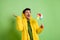 Photo of brunet impressed guy hold toy look empty space wear cloak isolated on green color background