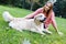 Photo of brunette hugging retriever on lawn