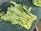 Photo of a bunch green mustard on vendor stall shelf.