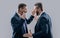photo of businessmen conflict with anger. two arguing businessmen in conflict isolated on grey