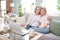 Photo of calm peaceful family mother and daughter sit sofa look laptop watch video indoors inside house home