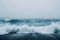 This photo captures a vast expanse of water with powerful waves crashing onto the shore, A minimalist representation of waves