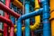 This photo captures the vibrant colors and numerous pipes inside a spacious industrial building, Brightly colored industrial pipes