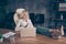 Photo of careless worker having raised his legs upon table making notes in her notepad sitting in front of laptop