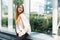 Photo of caucasian lovely woman smiling and looking aside while sitting near window in building indoors